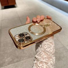 a woman holding up a gold phone case