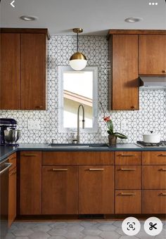 a kitchen with wooden cabinets and white tiled backsplash, along with an open window