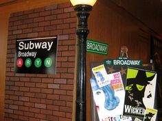 there is a sign on the side of this street light that says subway broadway and broadway