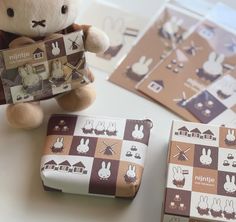 a stuffed animal sitting next to two small boxes with bunny designs on them and other items around it