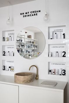 a bathroom sink sitting under a mirror next to a shelf filled with personal care items