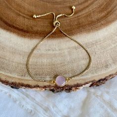 Rose Chalcedony Gold Bracelet / Pink Stone Dainty Adjustable Bracelet / Minimalist Boho Jewelry Minimalist dainty pink gemstone bracelet created with - a gold plated Rose Chalcedony connector - attached to a dainty gold plated brass chain with a slider bead that makes it adjustable - finished off with two gold ball ends Each bracelet is handmade to order and each stone is one of a kind so it may be slightly different than what is pictured. All of my bracelets come packaged in a kraft cotton fill Delicate Adjustable Round Charm Bracelet, Dainty Pink Bracelets With Adjustable Chain, Pink Dainty Bracelet With Adjustable Chain, Dainty Pink Bracelet With Adjustable Chain, Minimalist Adjustable Beaded Bracelet For Bridesmaids, Adjustable Minimalist Beaded Bracelet For Bridesmaids, Delicate Adjustable Jubilee Chain Bracelet, Adjustable Dainty Crystal Bracelet For Friendship, Dainty Adjustable Crystal Bracelet For Friendship