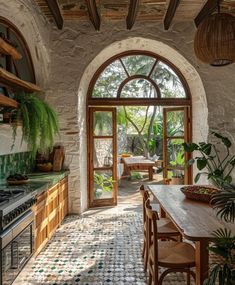 a kitchen with an arched doorway leading to the outside patio and outdoor dining area, along with potted plants