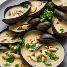 several clams in white sauce with garnishes and parsley on top