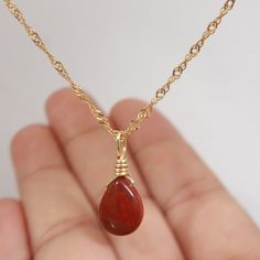 Introducing our stunning, handcrafted Red Jasper necklace with Pyrite accents, set in 18K Gold Filled chain. This exquisite piece of jewelry showcases the natural beauty and vibrant hues of Red Jasper, complemented by the sparkling Pyrite. Its unique and eye-catching design makes it the perfect accessory for any outfit, adding a touch of elegance and sophistication. Red Jasper is known for its grounding and stabilizing properties, while Pyrite is believed to promote prosperity and success. Toget Red Jasper Pendant, Affordable Red Spiritual Necklace, Gold Teardrop Pendant Necklace With Wire Wrapped, Gold Carnelian Pendant Necklace, Red Gemstone Drop Necklace For Gift, Gold Wire-wrapped Drop Necklace As Gift, Gold Teardrop Wire Wrapped Necklace, Gold Wire Wrapped Drop Necklace As Gift, Gold Wire-wrapped Drop Necklace For Gift