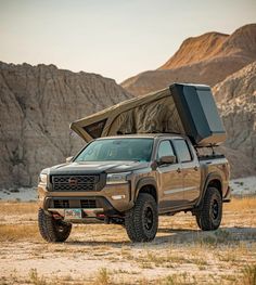 a truck with a camper attached to it's bed parked in the desert