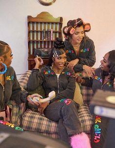 three women sitting on a couch with their hair done