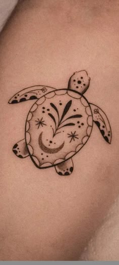 a black and white tattoo of a turtle on the back of a woman's stomach