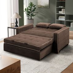 a brown couch sitting on top of a rug in a living room next to a book shelf