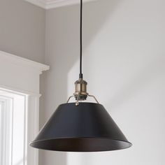 a black and gold pendant light hanging from a ceiling in a room with white walls