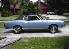 a blue car parked in front of a house