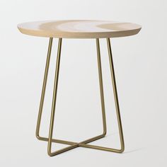 a small wooden table with metal legs and an intricate design on the top, against a white background