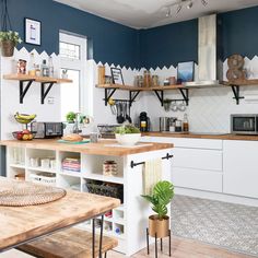 a kitchen with white cabinets and wooden counter tops