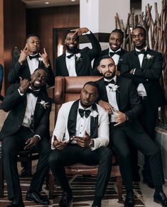 a group of men in tuxedos posing for a photo