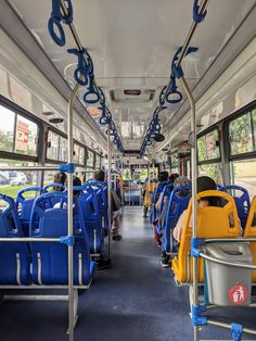 the interior of a public transit bus with blue and yellow seats