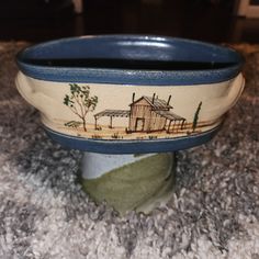 a blue and white bowl sitting on top of a carpeted floor next to a rug