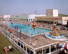 an overhead view of a pool with people playing in the water and onlookers watching