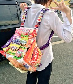 a woman with a back pack full of snacks in front of a car on the street