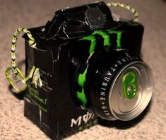 a camera made out of soda cans sitting on the floor next to a canister