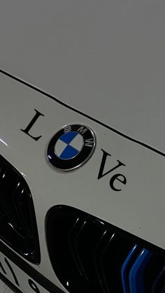 the front end of a white bmw car with love on it's grills