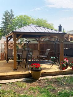 a wooden deck with a swing set and potted flowers