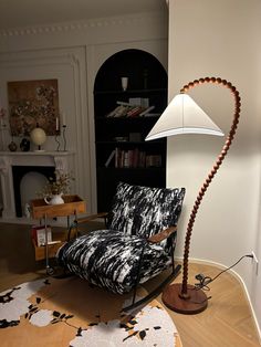 a living room with a chair, lamp and bookshelf