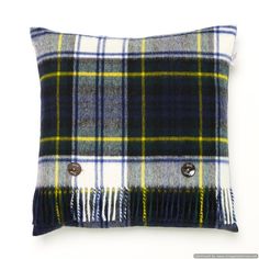 a blue and green plaid pillow with buttons on the front, sitting on a white surface