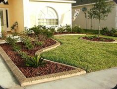 a house with landscaping in front of it and grass on the side walk to the front door