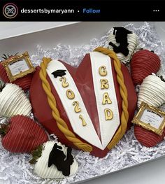 a cake in the shape of a heart with congratulations written on it, surrounded by strawberries