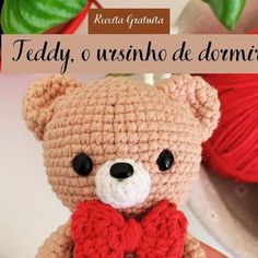 a crocheted teddy bear with a red bow tie