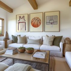 a living room filled with furniture and paintings on the wall above it's coffee table