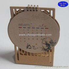 a calendar with chinese writing on it and a wooden stand for the front cover is made out of cardboard