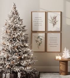 a white christmas tree in front of three framed pictures on the wall with candles next to it