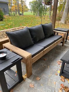 a wooden bench sitting on top of a patio next to a table and two chairs