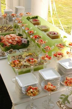 a long table filled with lots of food on top of plates and glasses next to each other