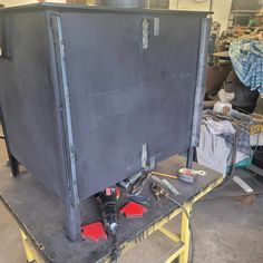 a large metal box sitting on top of a table next to tools and other items