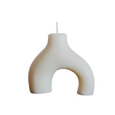 a white vase with a candle in the shape of an ointt on a white background