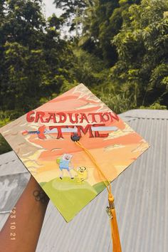 a graduate's cap with the words graduation time on it is held by someone