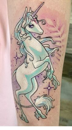 a tattoo with a unicorn on it's leg and stars in the sky behind it