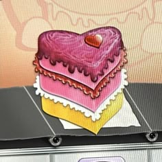 a heart shaped cake sitting on top of a counter in front of a computer screen