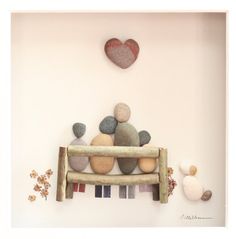 some rocks are sitting on top of a wooden bench with a heart above the bench