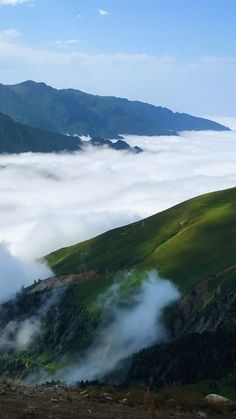 the mountains are covered in low lying clouds