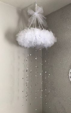 a white cloud hanging from the ceiling next to a clock