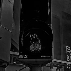 a black and white photo of a traffic light with an image of a rabbit on it