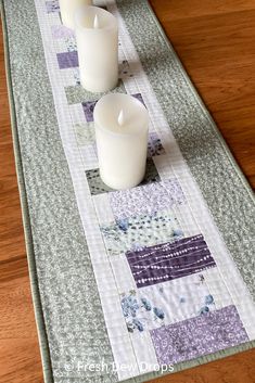 three white candles sitting on top of a table