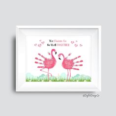 two pink flamingos are standing in the grass with their handsprints on them