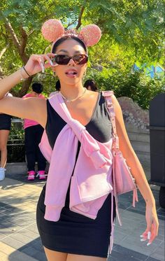 a woman wearing minnie mouse ears is posing for the camera