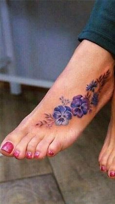 a close up of a person's foot with purple flowers on the bottom of it