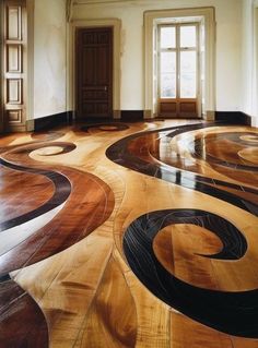 a large room with wooden floors and circular designs on the floor