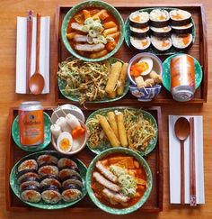 a wooden table topped with plates and bowls filled with food